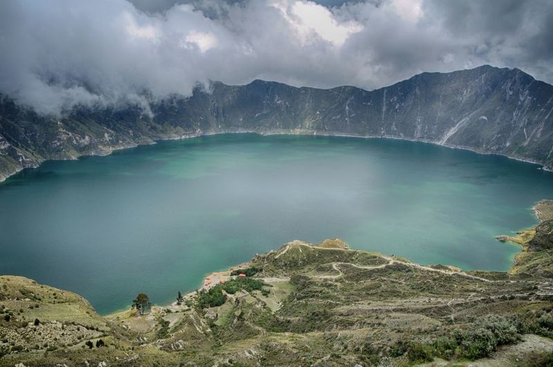 Scenic view of lake and mountains against cloudy sky