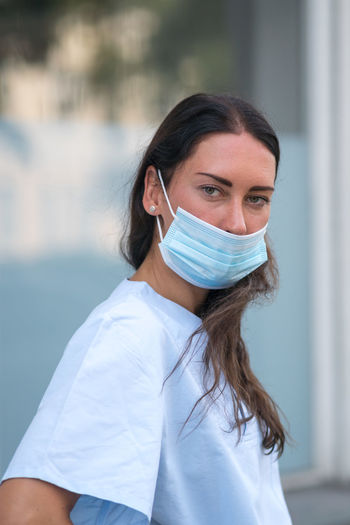 Medical worker posing covering her face with a protective mask