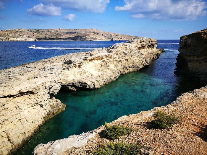 High angle view of rocks by sea against sky