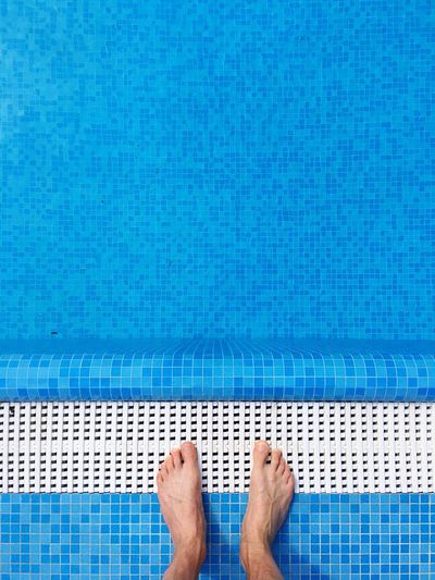 Low section of man standing at poolside