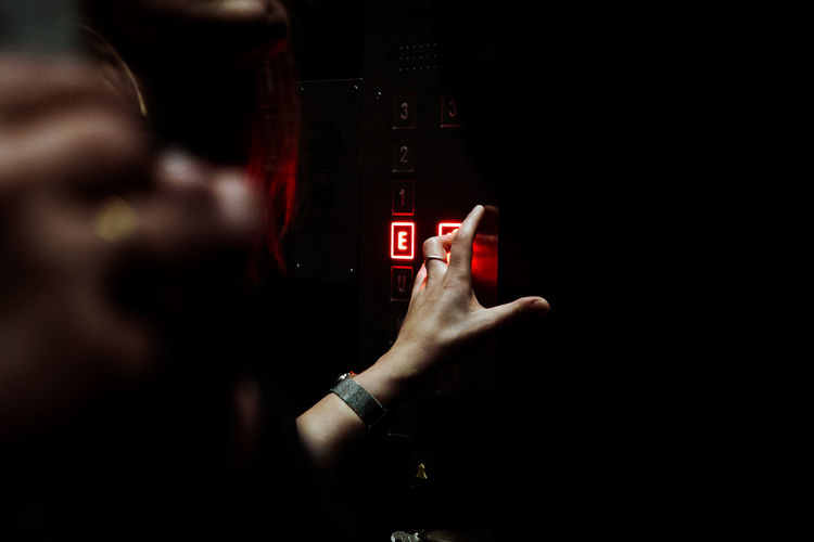 Cropped hand of woman pushing elevator button