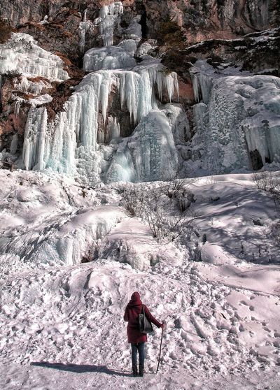 Full length of person standing on rock in winter