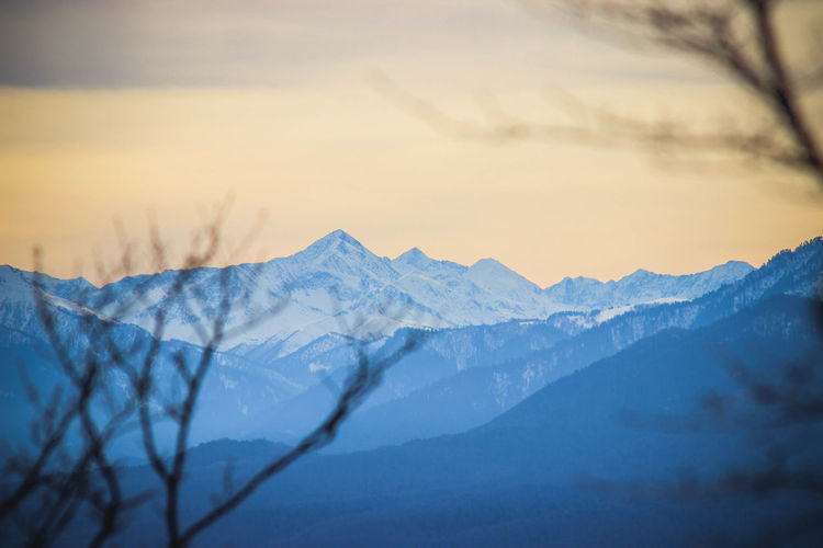 Scenic view of snowcapped mountains against sky during sunset