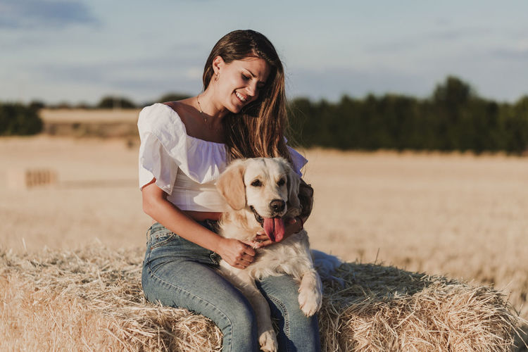 Mid adult woman with dog on agricultural field