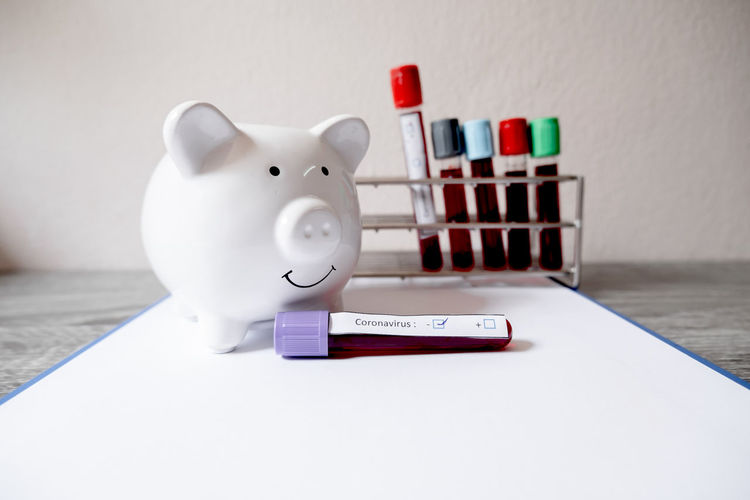 Close-up of piggy bank with blood samples on table