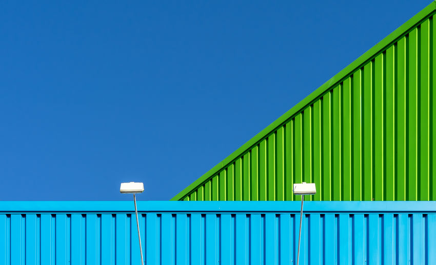 Metallic structure by building against clear blue sky