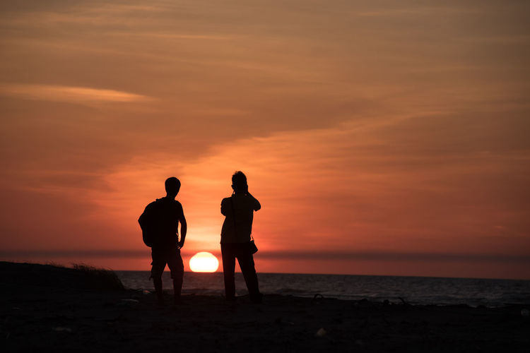 Silhouette of people on beach during sunset