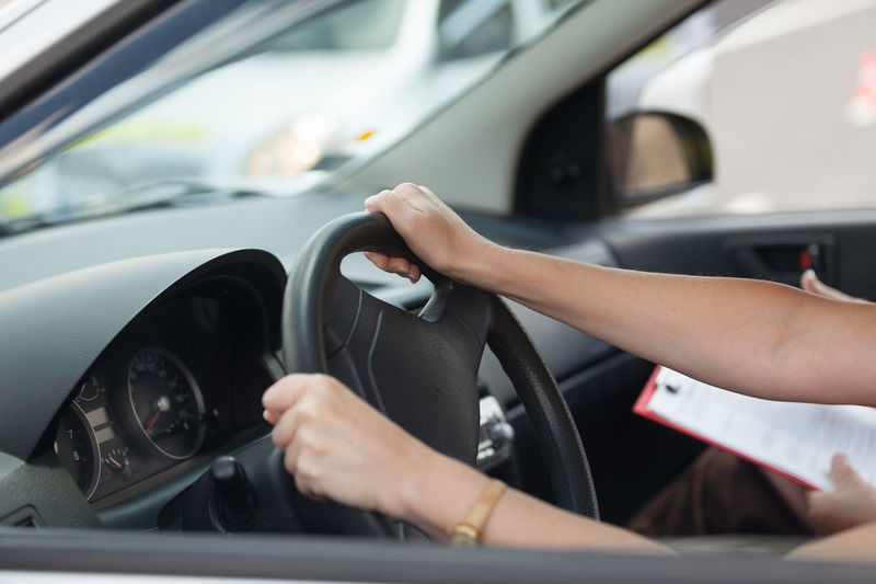 Woman with instructor driving car in city