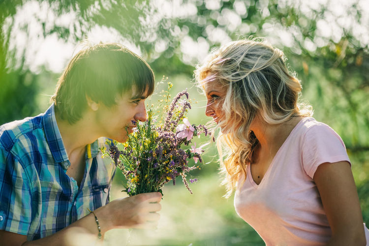 Man looking at woman with bouquet in hand