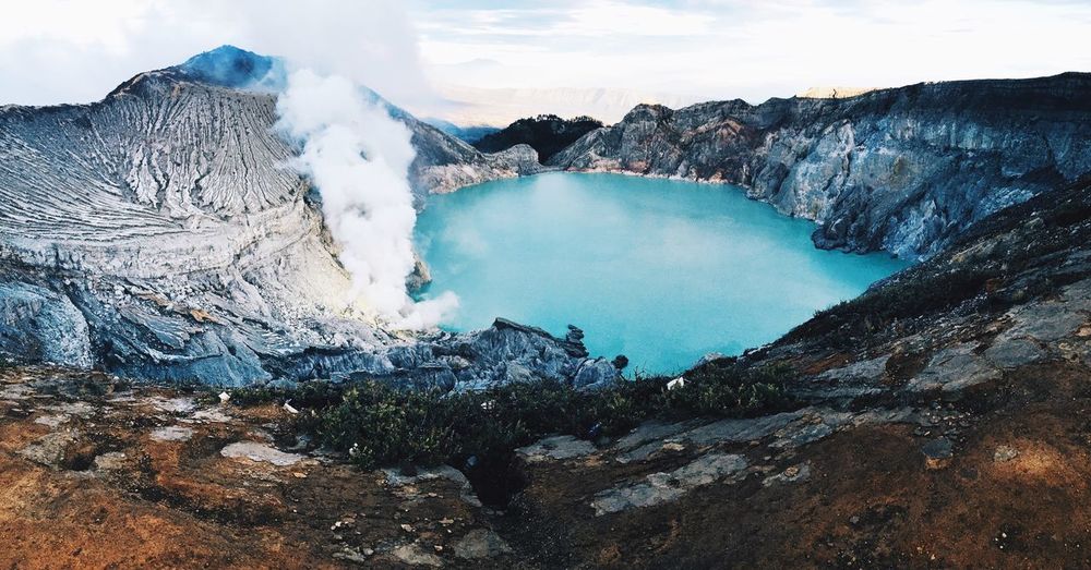 Scenic view of lake amidst volcanic mountains against sky