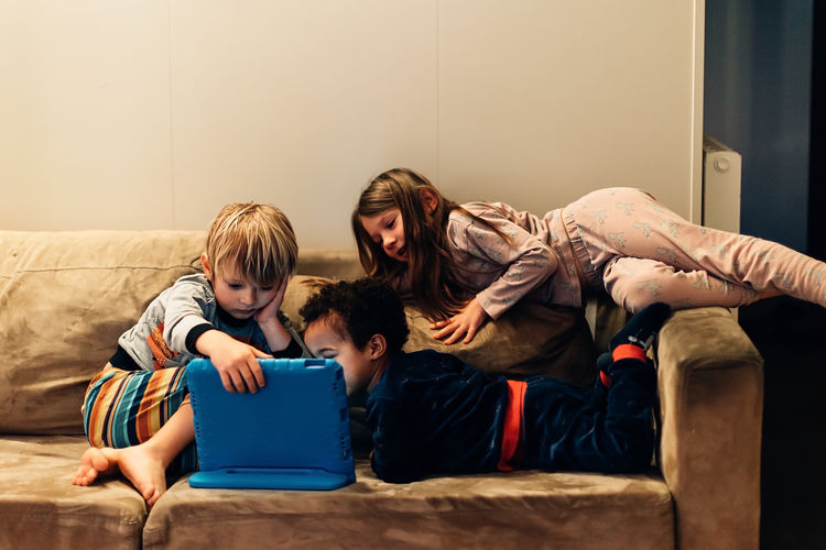 Children watching tablet on the couch before going to bed
