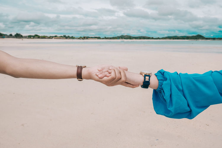 Couple holding hands at beach