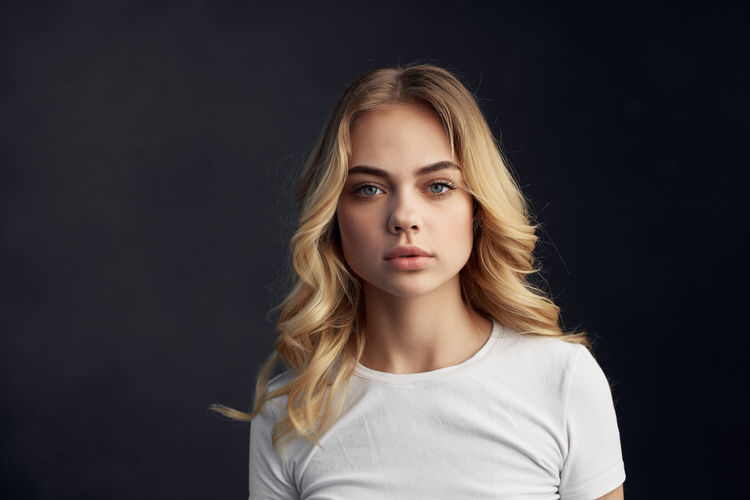 Portrait of beautiful young woman over black background