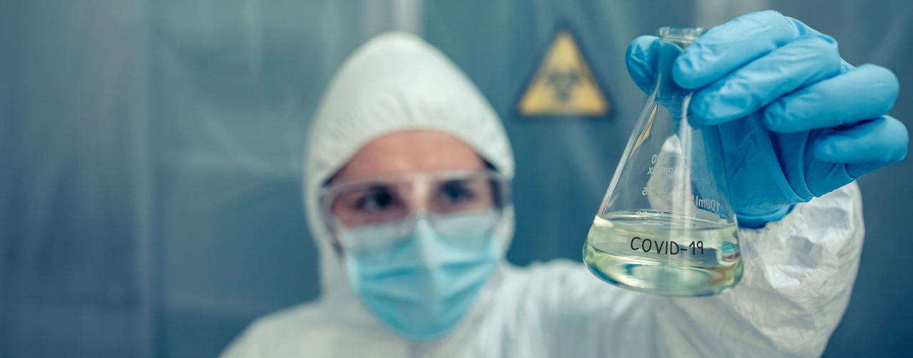 Close-up of scientist holding liquid in flask