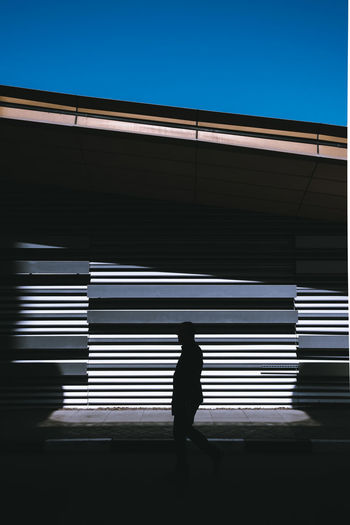 Silhouette man walking against clear sky