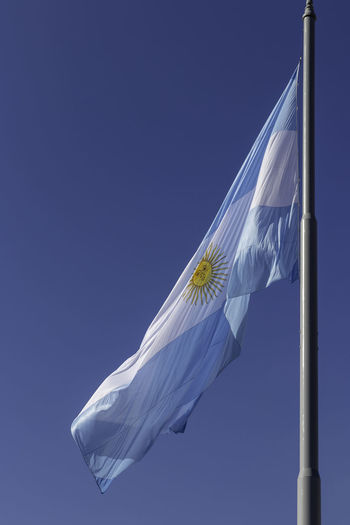 Low angle view of argentinian flags against clear blue sky