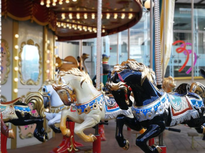 View of carousel horses in amusement park