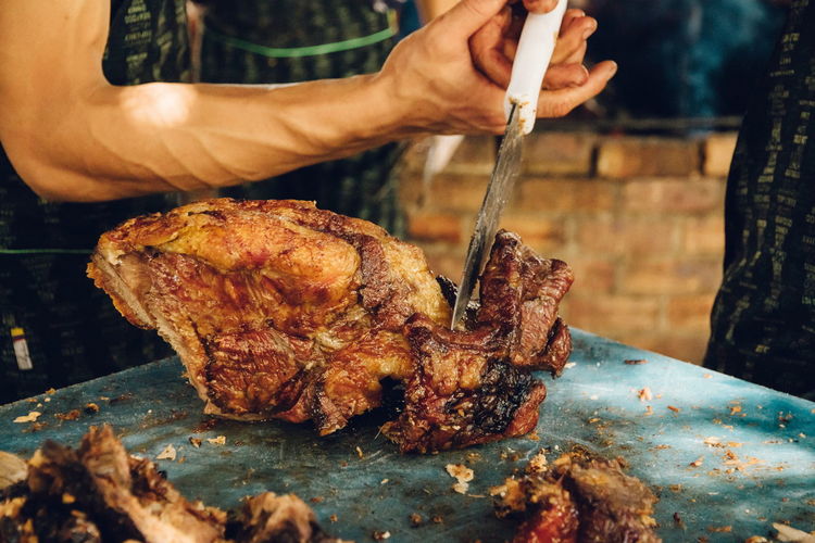 Close-up of man preparing food on barbecue grill