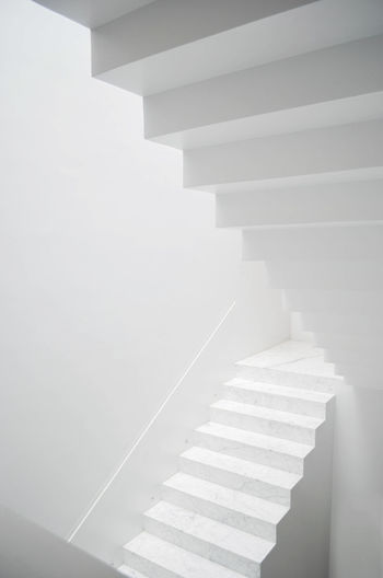 LOW ANGLE VIEW OF STEPS AGAINST WHITE WALL