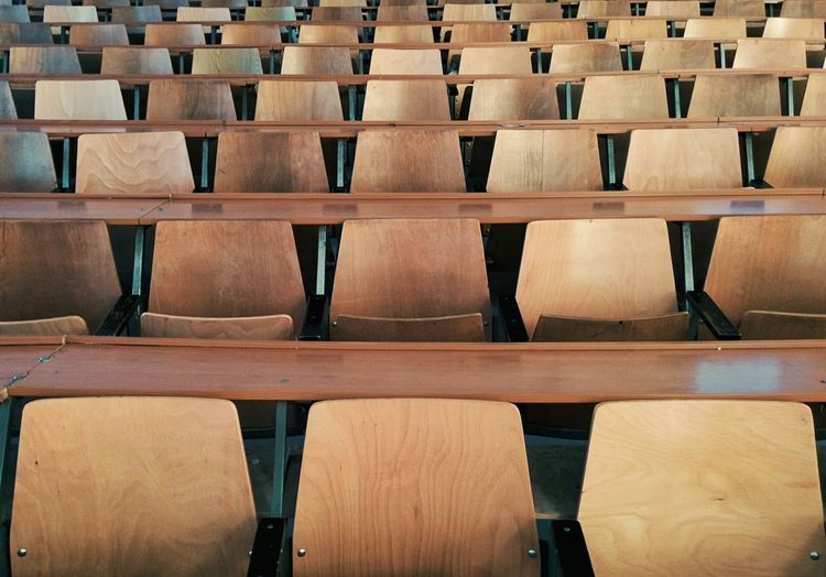 Full frame shot of wooden chairs in auditorium