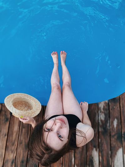 Low section of woman against swimming pool