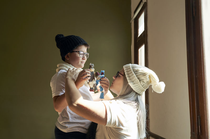 Boy with glasses looks at his mother