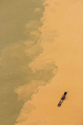 Aerial view of cormorant fisherman paddling on his bamboo raft at the li river, china 
