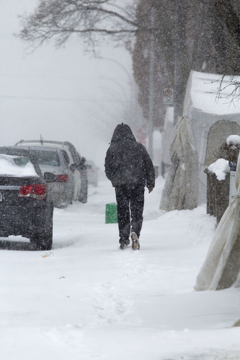Guy walking under snow storm