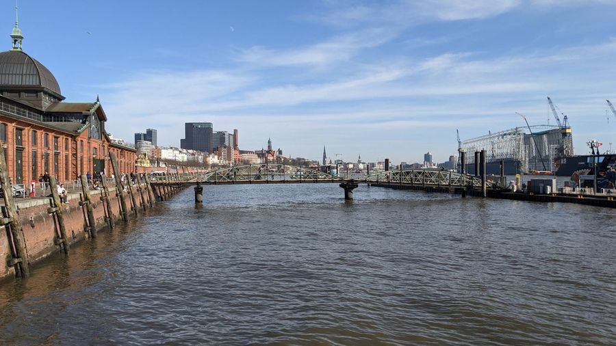 Bridge over river against buildings in city