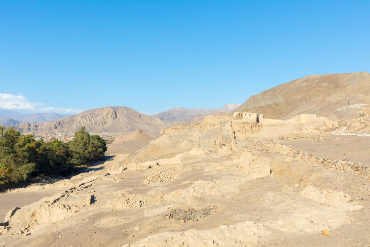 Scenic view of desert against clear blue sky