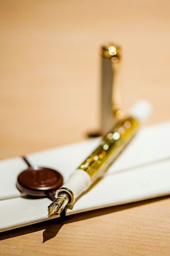Close-up of golden pen on table