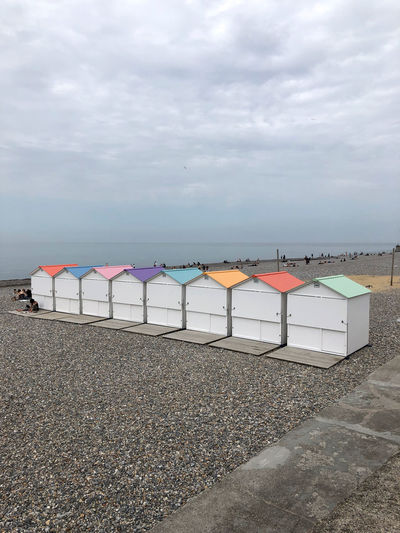 Beach umbrellas by sea against sky
