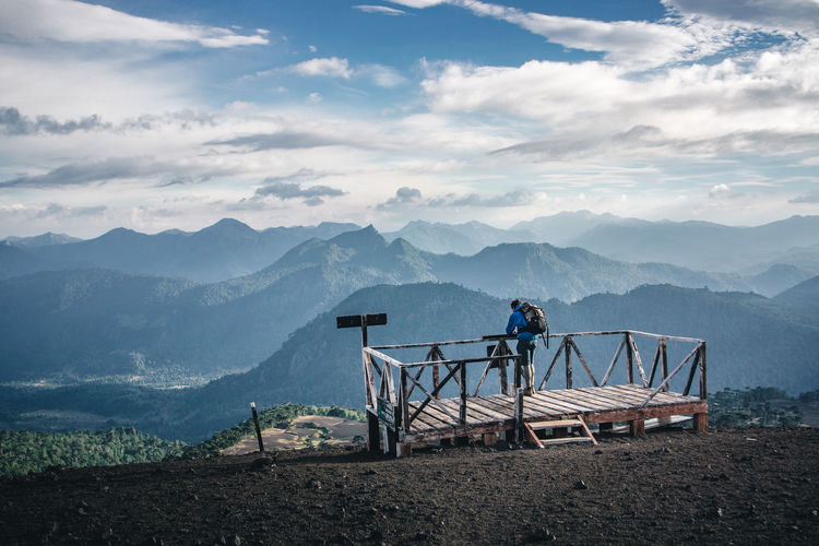 Man standing at observation point against mountains