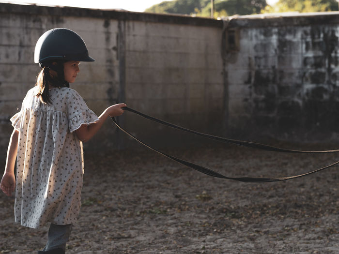 Asian school kid girl with horse ,riding or practicing horse ridding at horse ranch.
