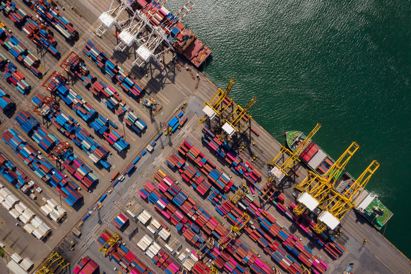 Container ship loading and unloading in sea port, aerial view of business logistic import 
