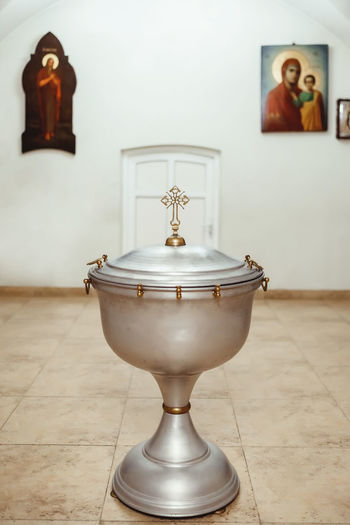 A silvery church font, decorated with gold elements