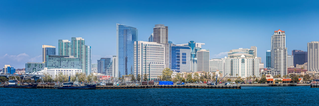 Modern buildings in city against clear blue sky