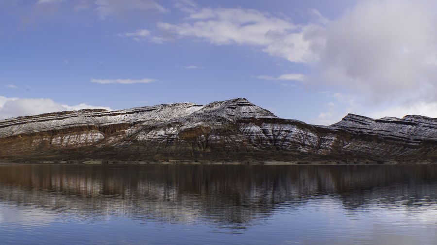 Scenic mountain in southern utah with snow on ridges of cliffs reflected in quail creek reservoir 