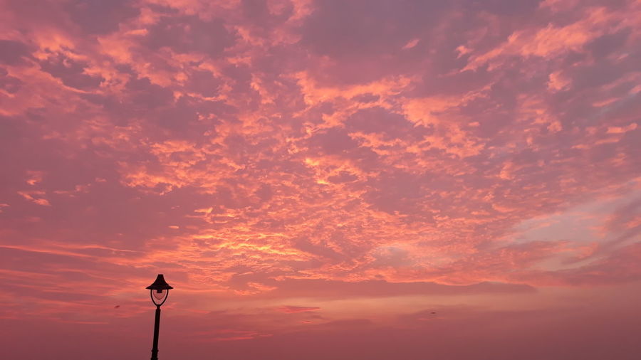 Low angle view of street light against cloudy sky