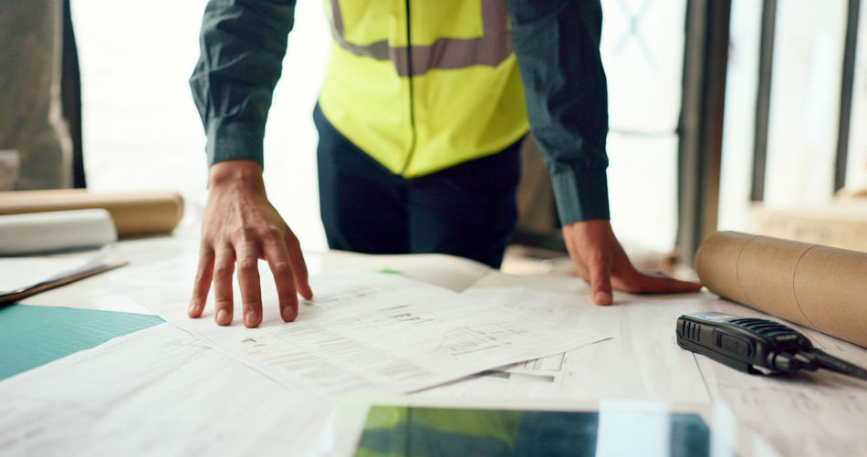 Midsection of architect working on table