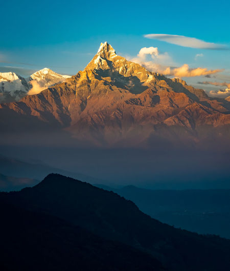 Scenic view of mountain range against blue sky