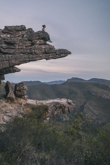 Woman sits at the top of the balconies and looks the landscape of the grampians national park, victoria, australia