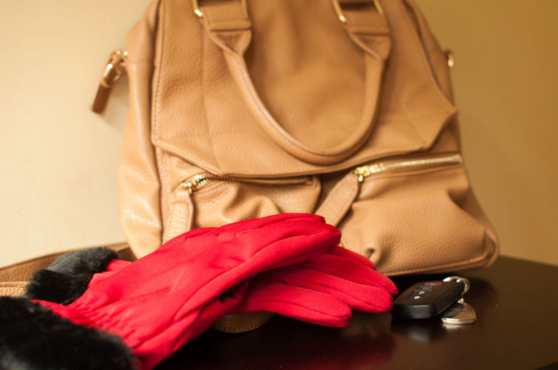 Close up of gloves with bag and car key on table at home