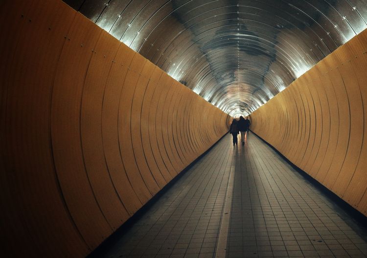 Man standing in illuminated tunnel