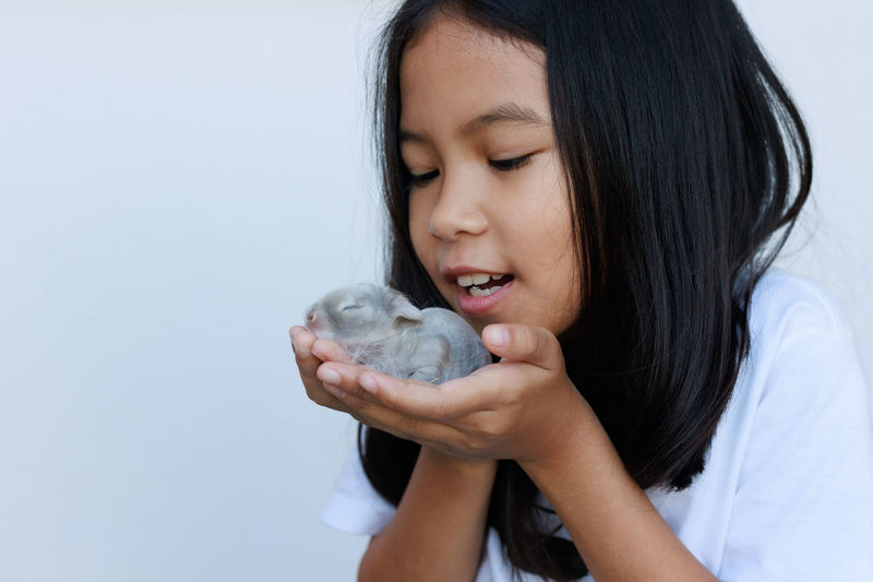 Close-up of girl holding baby rabbit