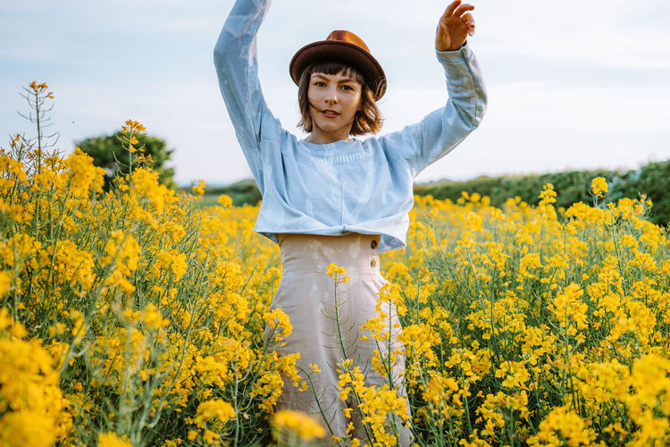 Portrait of woman standing amidst flowers