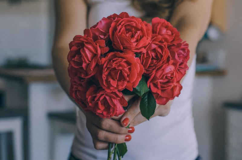 Close-up of hand holding rose bouquet