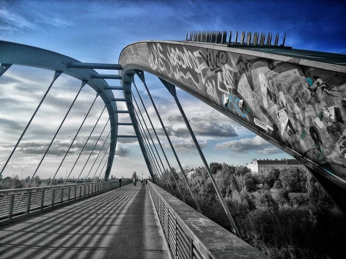 Low angle view of bridge against cloudy sky