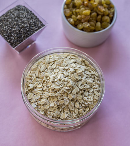 High angle view of oats and raisins in containers on table