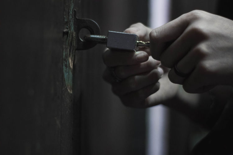 Cropped hands of person opening lock